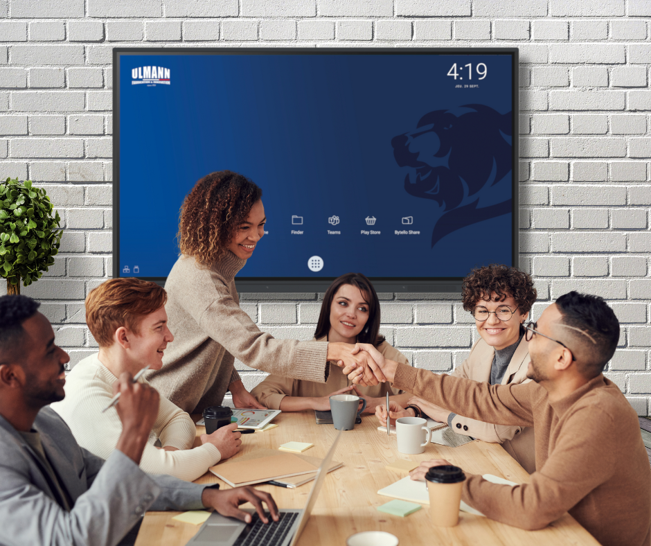 Salle de réunion avec 6 personnes qui collaborent devant un écran interactif ulmann touch